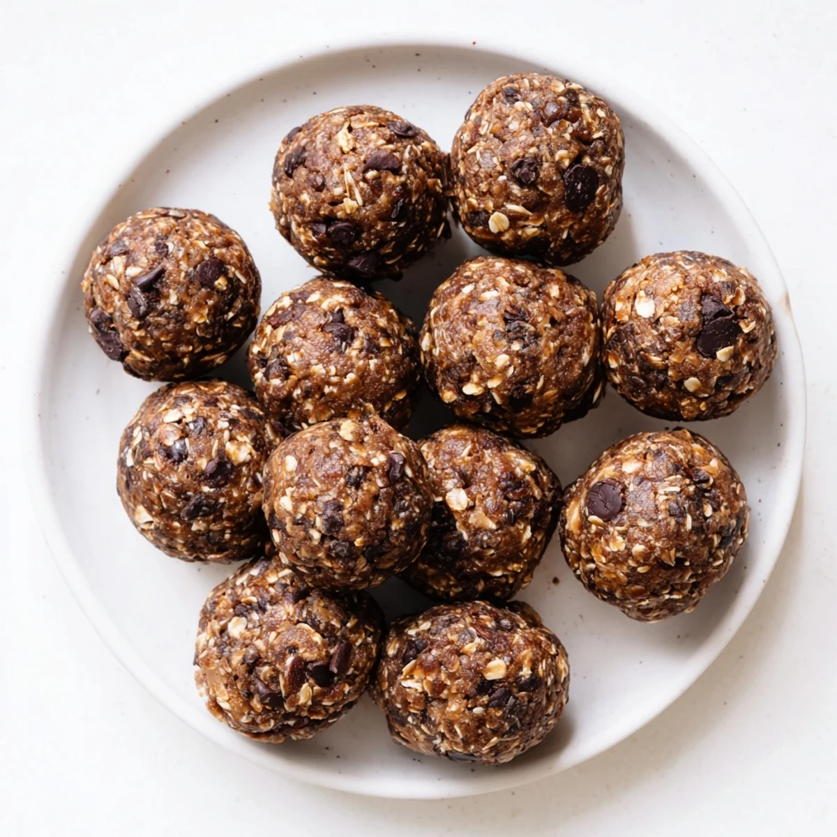 Homemade protein energy balls rolled by hand featuring creamy peanut butter and rich cocoa powder dusted surface