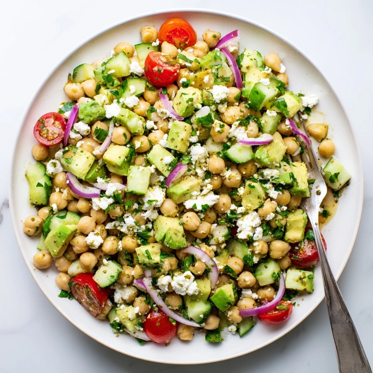 Protein-rich chickpea feta avocado salad tossed with red onion, cucumber, and tangy citrus vinaigrette