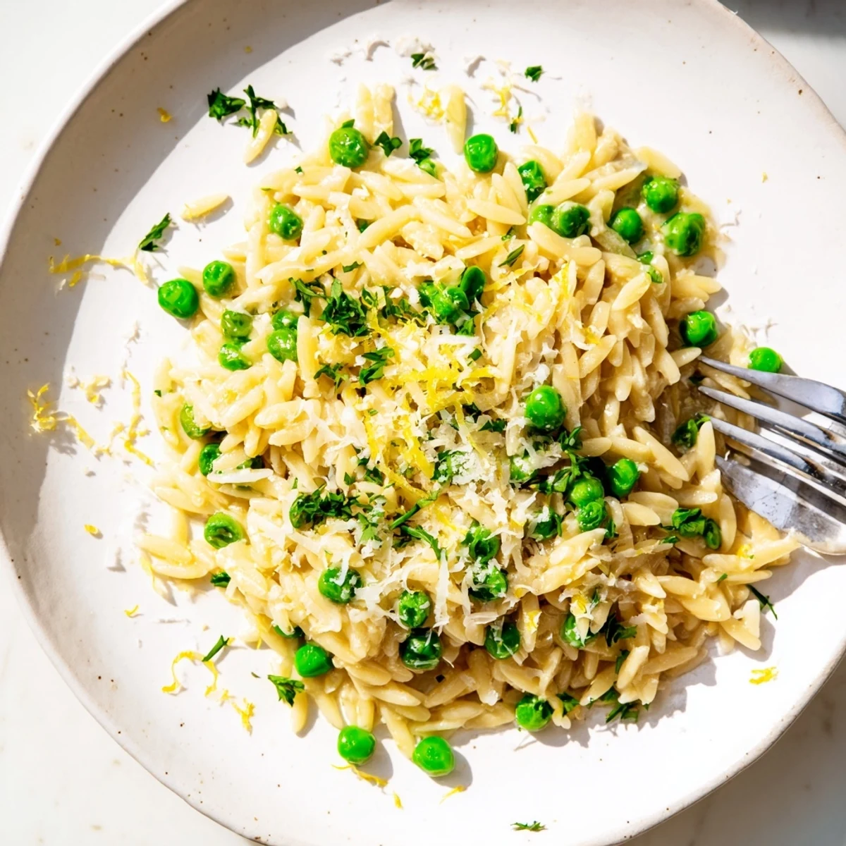 Golden lemon orzo side dish garnished with chopped parsley and extra Parmesan on top