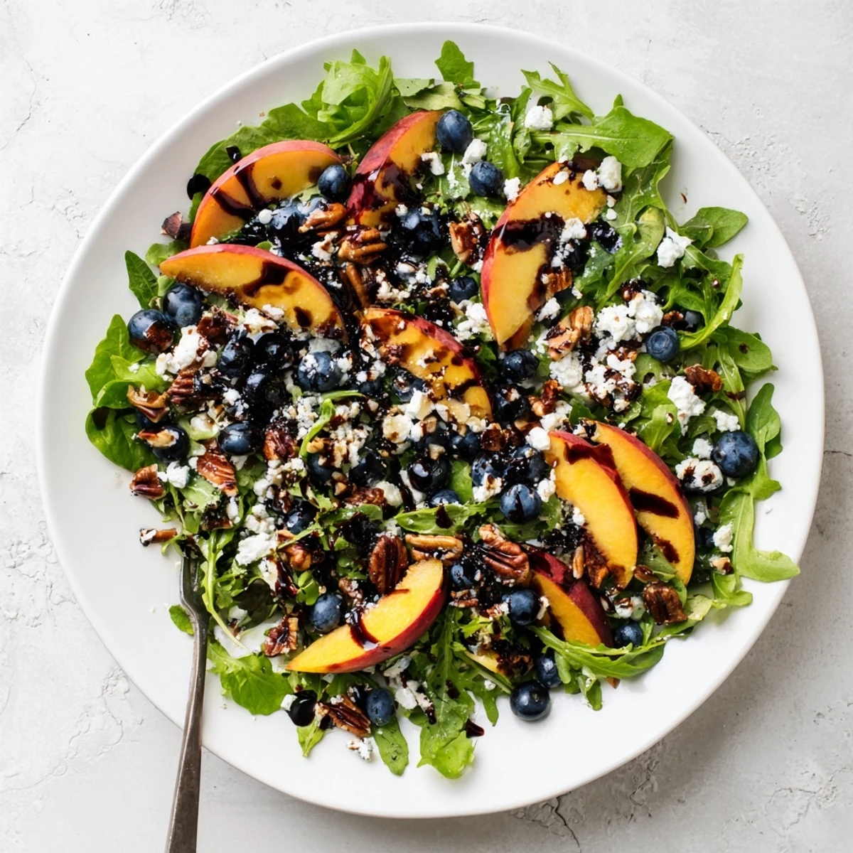 Vibrant blueberry peach feta salad bowl featuring ripe sliced peaches, juicy berries, and crumbled feta cheese