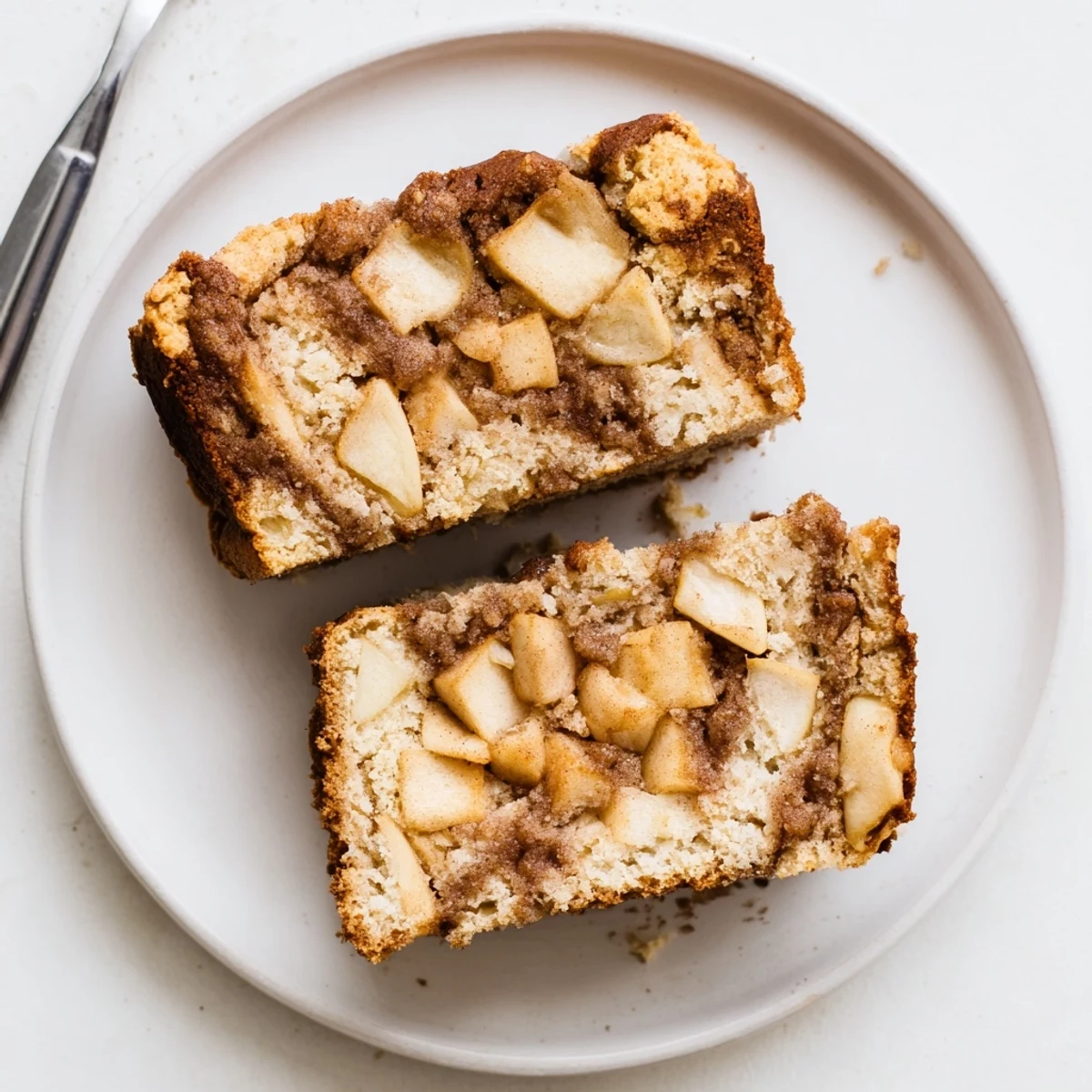Golden cinnamon apple bread loaf with apple chunks peeking through the browned crust