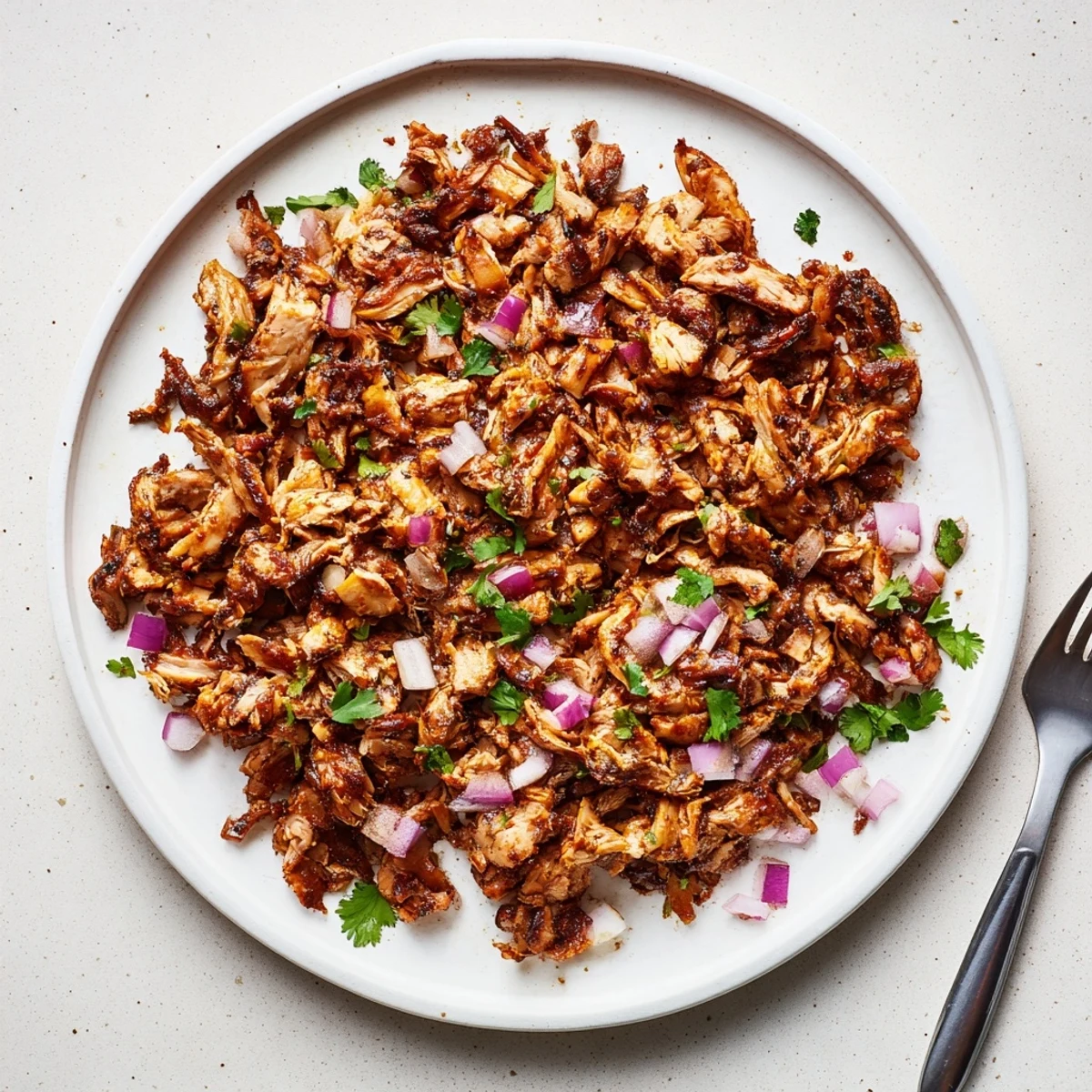 Crispy spiced mushroom carnitas arranged on a platter with diced red onion