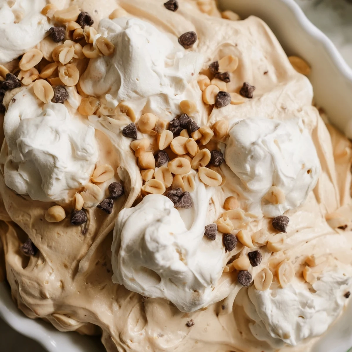 Light and fluffy peanut butter mousse dessert swirled with Cool Whip and garnished with peanuts for an easy sweet treat