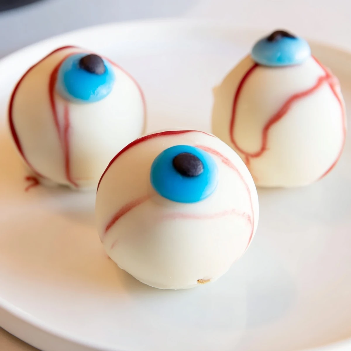 Halloween Cake Eyeballs with red veins and colorful irises on a dark platter