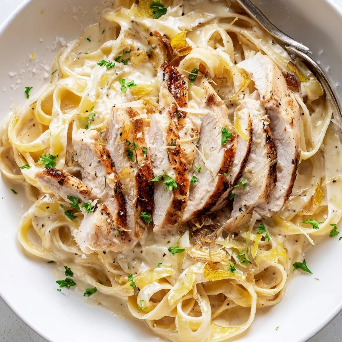 Creamy Garlic Chicken Pasta steaming fettuccine tossed in silky garlic Parmesan sauce