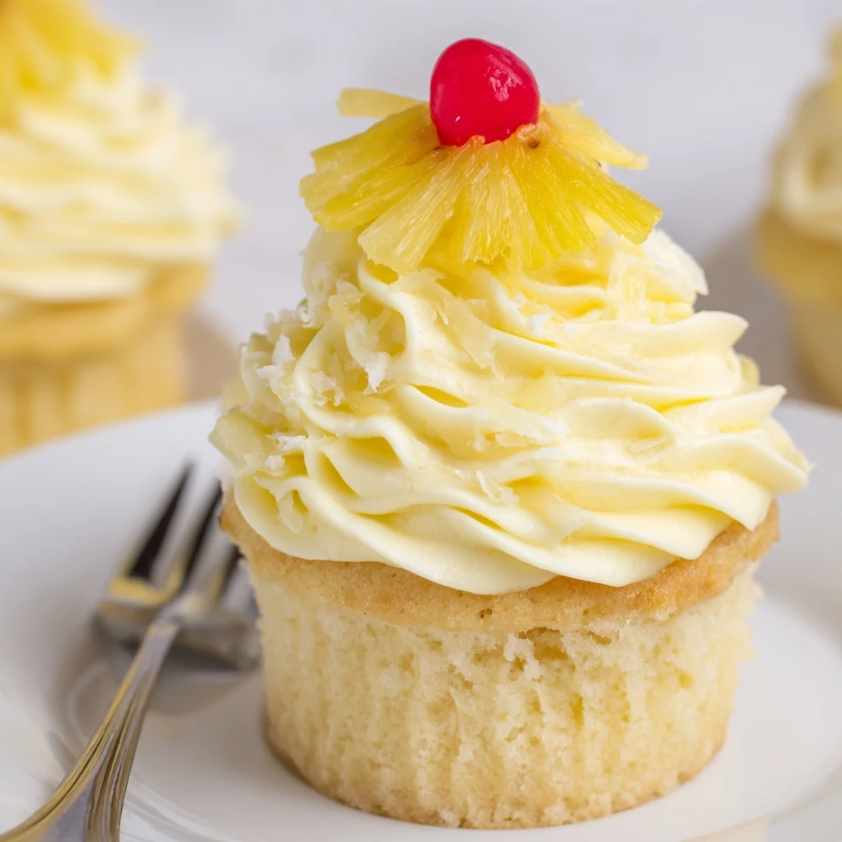 On a wire rack, Dole Whip Cupcakes Recipe cooling, topped with maraschino cherry