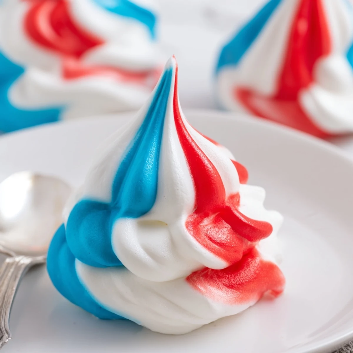 Plated Patriotic Meringue Kisses piled in a jar, airy bites that melt