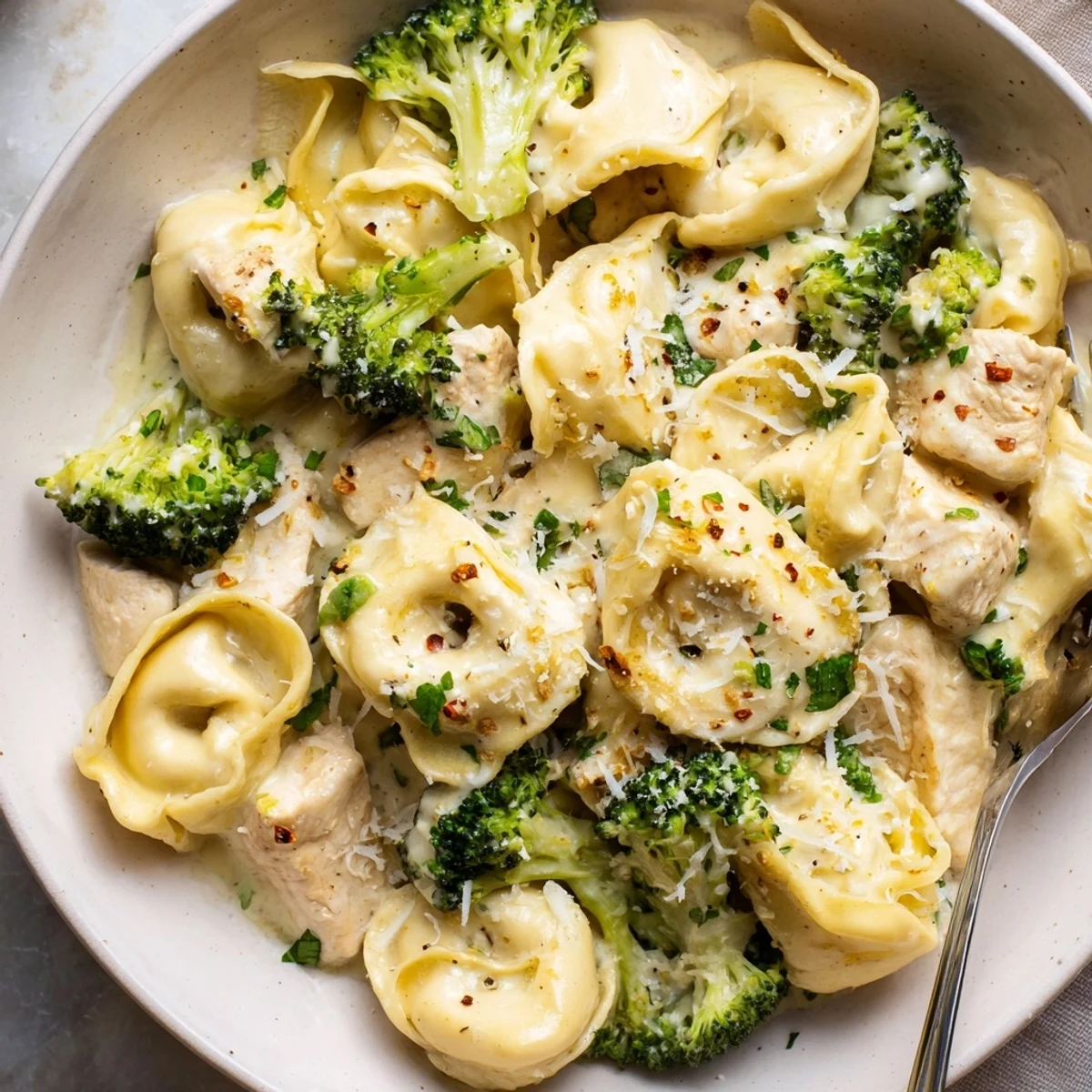 Creamy Garlic Parmesan Tortellini Chicken Broccoli Recipe plated steaming, ready to eat