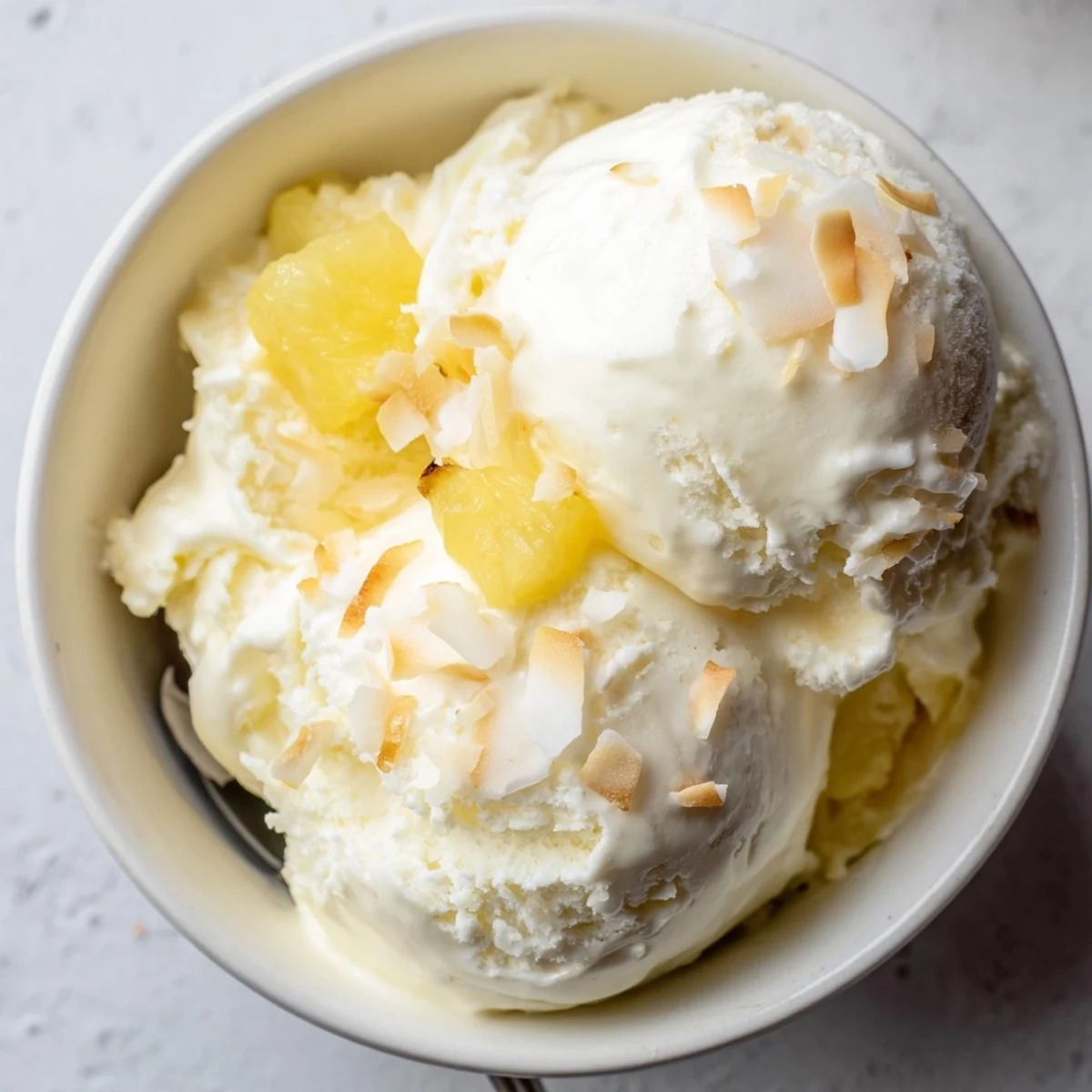 Homemade Creamy Pineapple Ice Cream shown churning, ready for freezer.