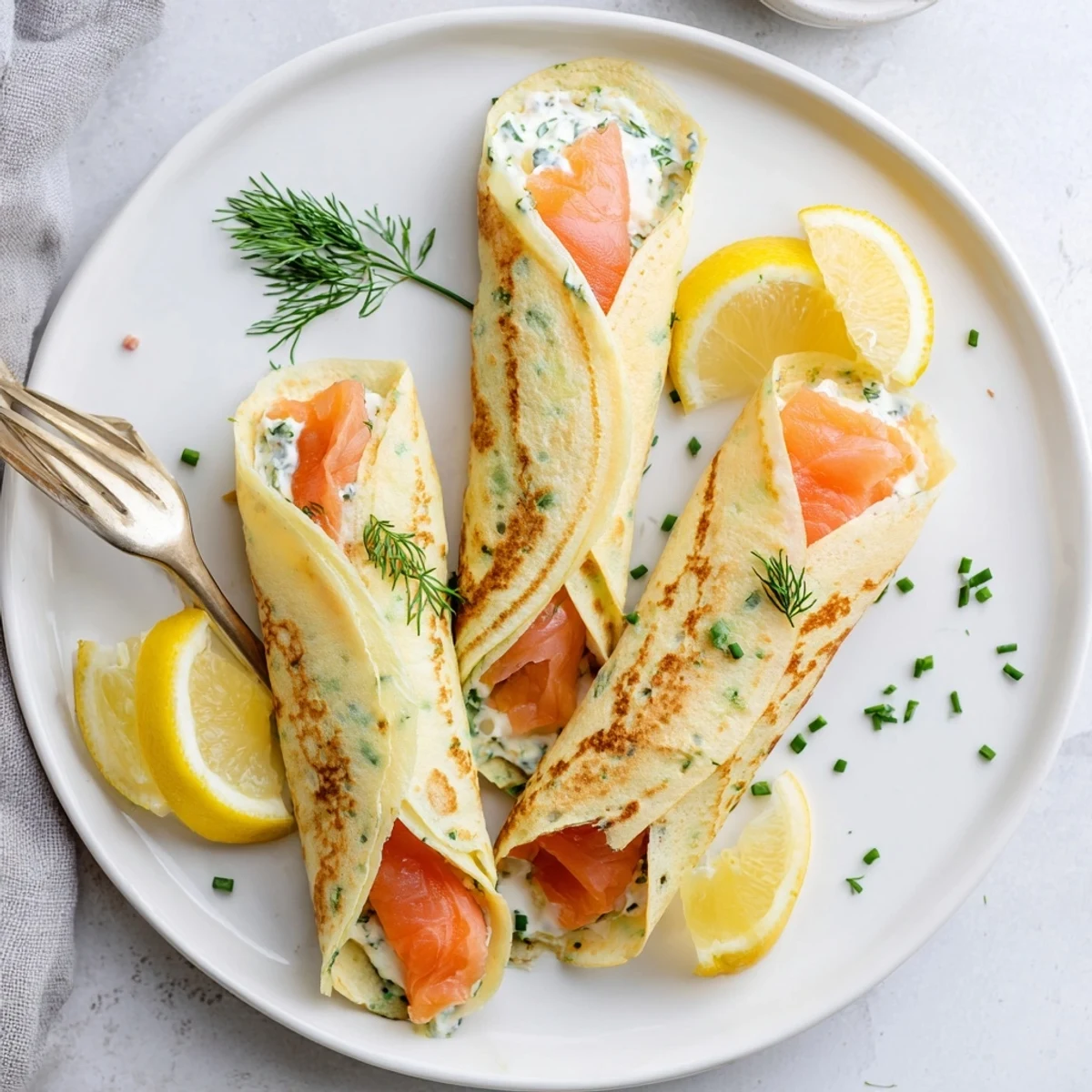 Thin French crepes wrapped around silky smoked salmon with fresh dill and lemon garnish