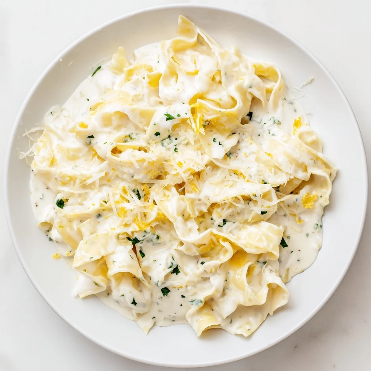 Golden creamy cafeteria noodles tossed in rich Parmesan sauce with fresh parsley garnish