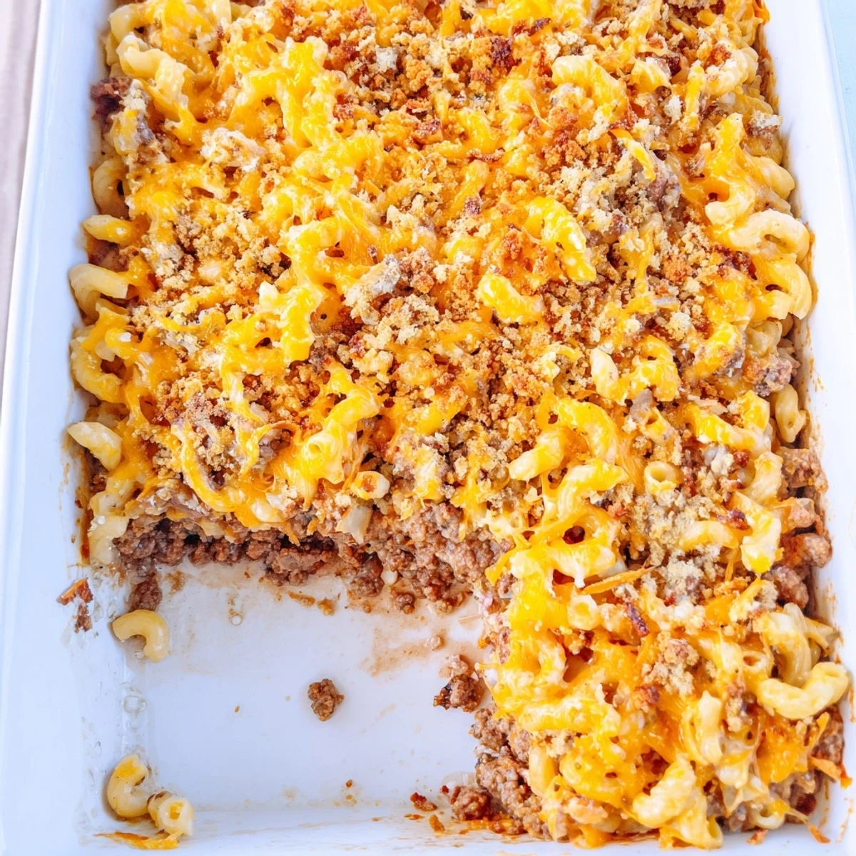 Steaming slice of Mac and Cheese Meatloaf Casserole showing both beef and pasta layers melted together